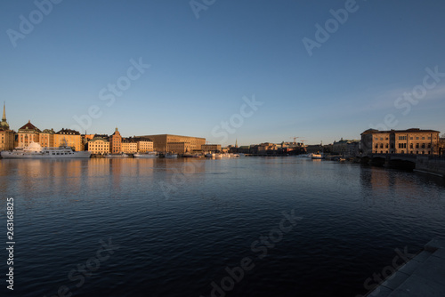 A sunny early spring day in Stockholm, view over a pier with boats and birds at the old town and the Södermalm district  © Hans Baath