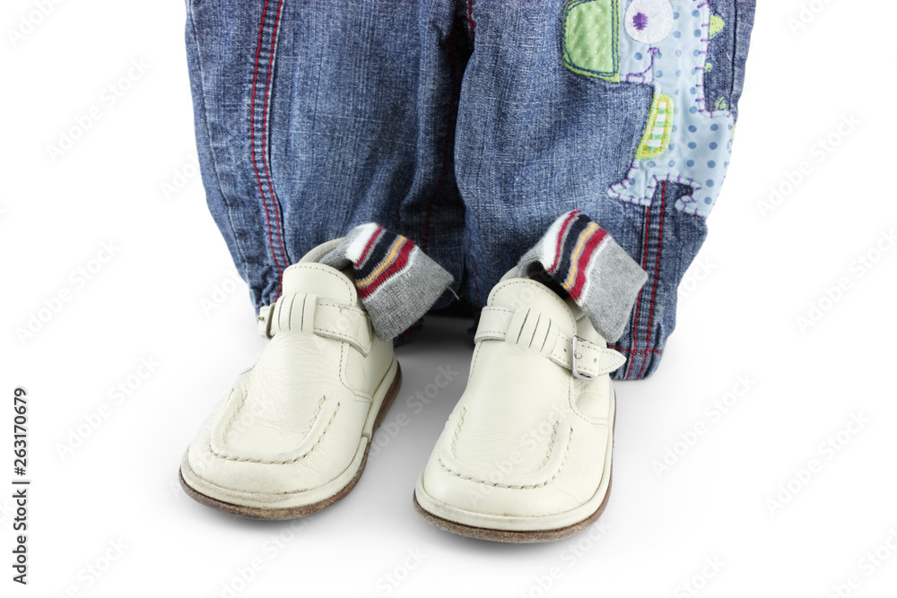 pair of baby boots and jeans on white background 