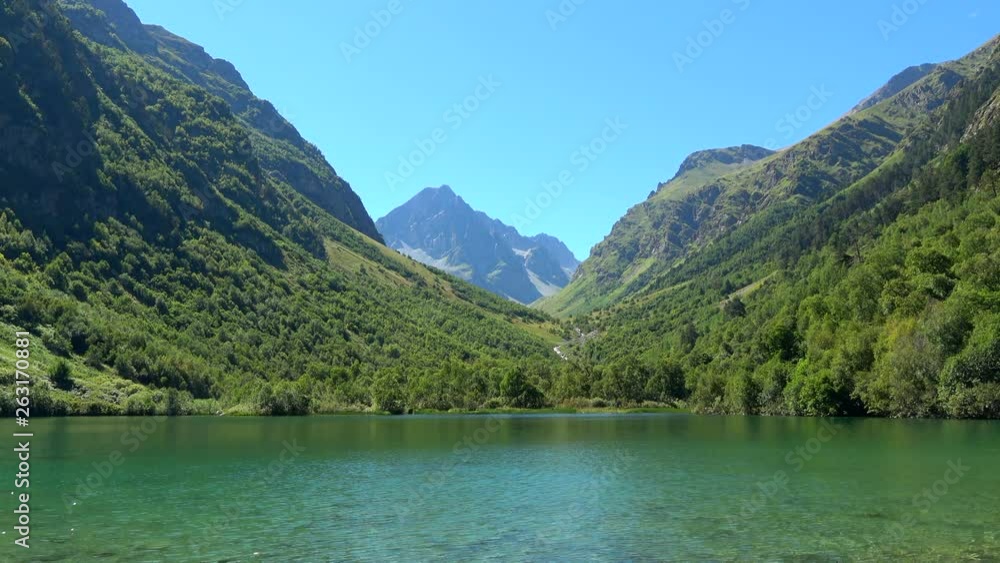 View lake scenes in mountains, national park Dombai, Caucasus, Russia, Europe. Summer landscape, sunshine weather, blue sky and sunny day View lake scenes in mountains, national park Dombai, Caucasus, Russia, Europe. Summer landscape, sunshine weather, blue sky and sunny day