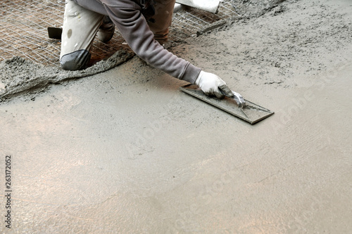 Bild auf Leinwand Worker flattening cement mortar on floor