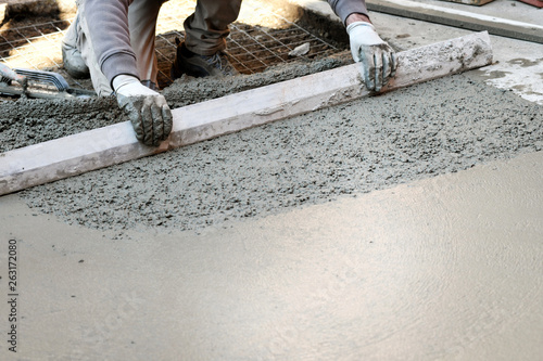 Worker flattening concrete floor