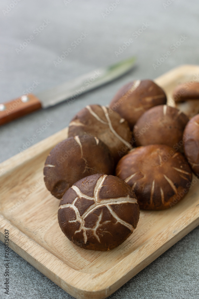 shiitake in wooden dish on concrete table. shiitake in wooden dish on concrete table.