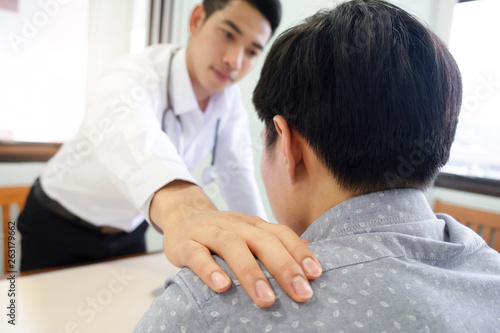 Doctor comforting patient at consulting room.