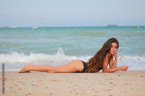 Woman on the beach enjoying the summer by the sea