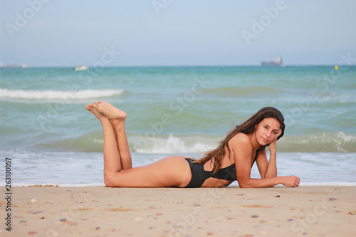Woman on the beach enjoying the summer by the sea