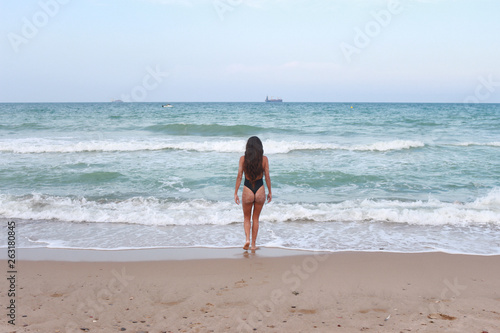 Woman on the beach enjoying the summer by the sea