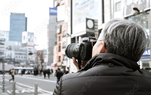 Adult people photographer journalist travelers take photo billboard building or businesson shopping neon street of shinjuku area at Tokyo, Japan