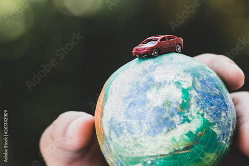 Eco friendly Save world concept. Red car and Hands holding Model globe clay with radar Natural background. Ideas of earth maintenance by reducing energy consumption, Travel around the world