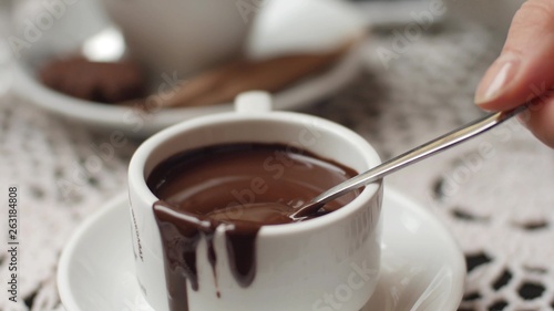 hand mixing chocolate in a hot milk, preparing hot chocolate or cacao, bautiful soft focus shot