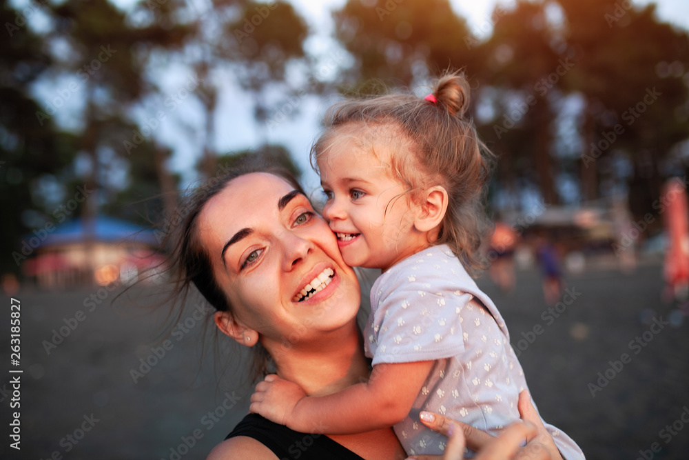 Happy mother and her little daughter outdoor.