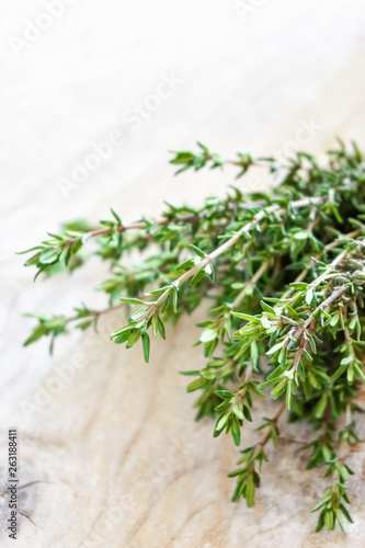 Closeup of a bunch of fresh aromatic green thyme herb on old wood background with copy space. Vertical image.