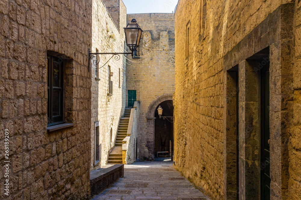 Narrow way or street between walls of buildings in Castel