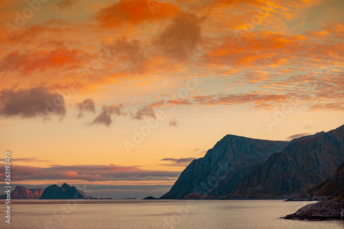 Island on the horizon. Rocks in the sea. Beautiful rocky shore of the fjord in the evening. Wild nature Norway  seascape. Gradient color