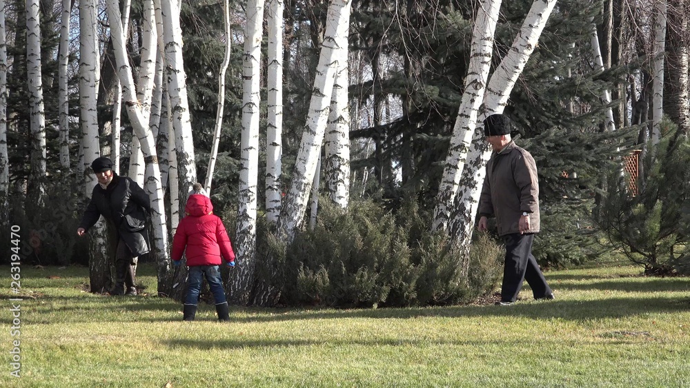 Grandparents and grandchild playing in the park, hide and and seek joy Grandparents and grandchild playing in the park, hide and and seek joy