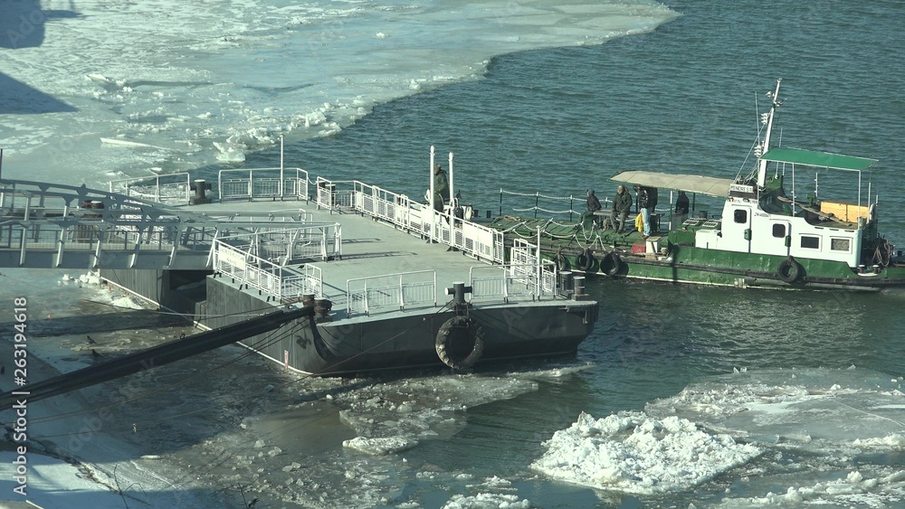 Naklejka premium Man land ship on port, frozen river