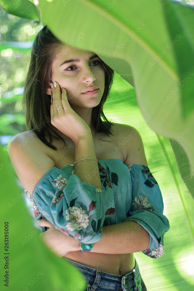 Naklejka premium Sexy young brunette beauty in a rain forest