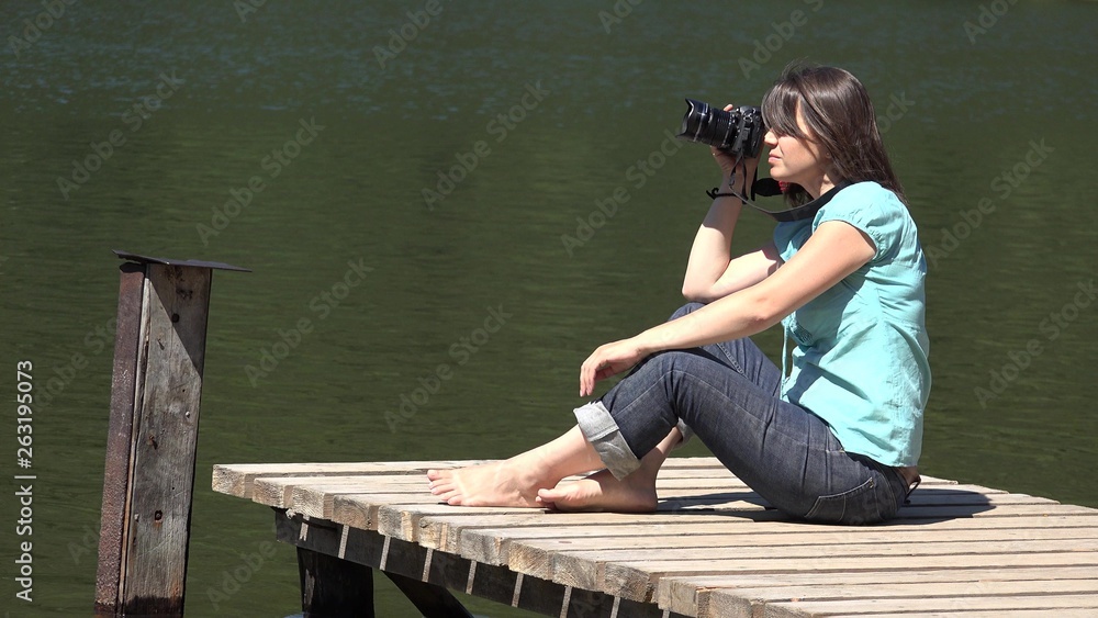 Attractive woman taking pictures in nature, professional camera, beautiful hobby