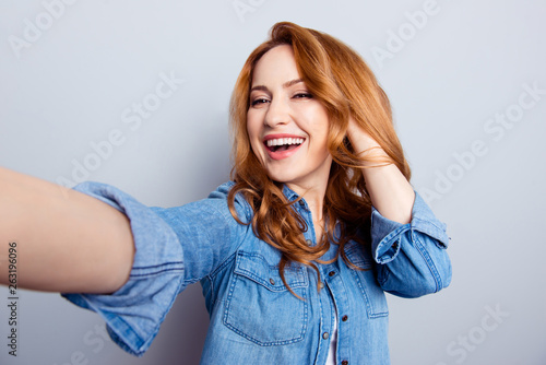 Close up photo beautiful amazing she her lady make take selfies modern technology show perfect ideal teeth hold arm hand hairstyle wear casual blue jeans denim shirt isolated grey background