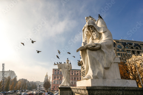 Pigeons fly over Monument to Princess Olga, Saint Andrew, Sts. Cyril and Methodius in Kyiv, Ukraine.  photo