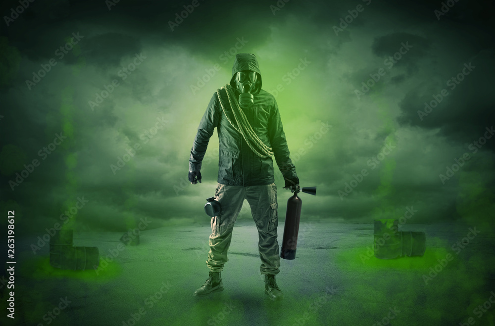 Fototapeta premium Masked unrecognizable guard in an abandoned space after explosion