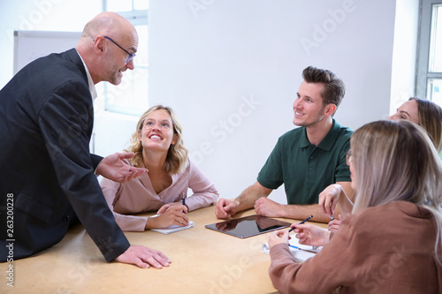 Chef diskutiert mit jungen Mitarbeitern