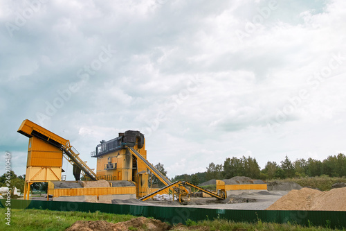 Mobile concrete batching plant. Equipment for production of asphalt, cement and concrete for road works. Cement production factory on mining. Conveyor belt of heavy machinery loads stones and gravel