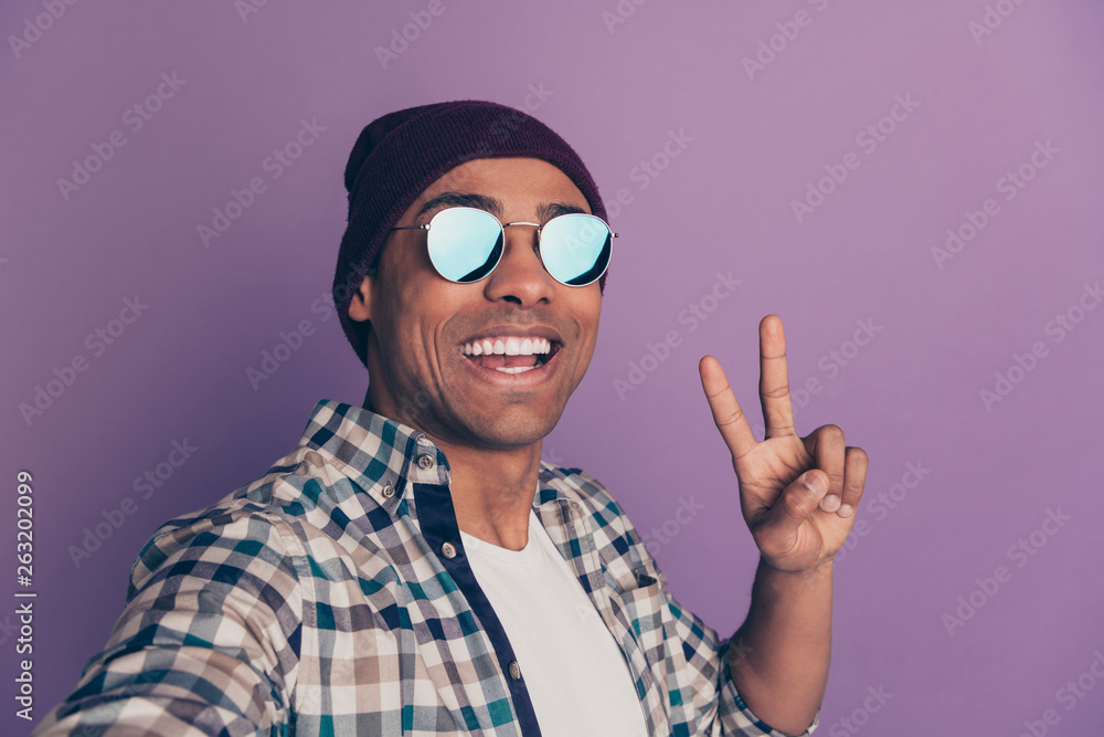 Close up photo portrait of cool handsome attractive nice cheerful positive glad optimistic guy making video call to friends showing v-sign white teeth isolated violet background Close up photo portrait of cool handsome attractive nice cheerful positive glad optimistic guy making video call to friends showing v-sign white teeth isolated violet background