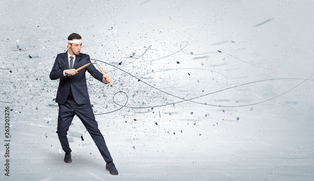 Young suited karate trainer doing karate tricks with chaotic concept
