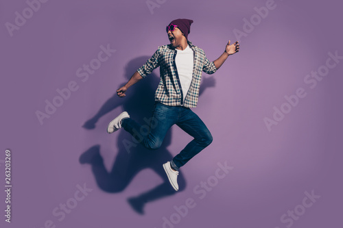 Full length size body side profile photo of cheerful handsome screaming in jeans denim clothes modern star eyewear millennial isolated violet background