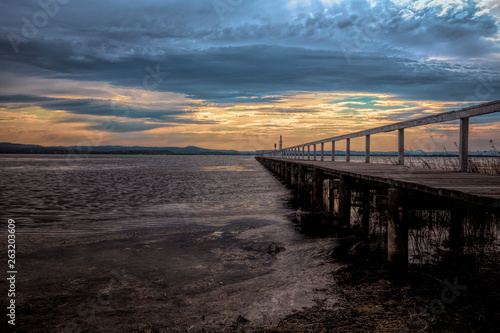 A long jetty jutting out into a large tidal lake.