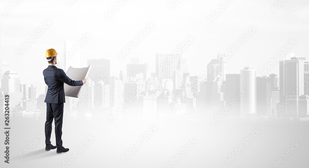 Young supervisor architect standing and looking at a big city panorama
Young supervisor architect standing and looking at a big city panorama
