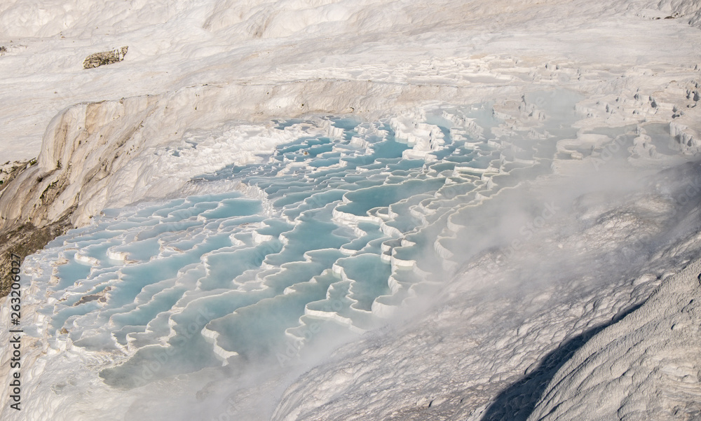 Fototapeta premium The pools of Pamukkale in Turkey. Pamukkale contains hot springs, travertines and terraces of carbonate minerals. UNESCO World Heritage Site