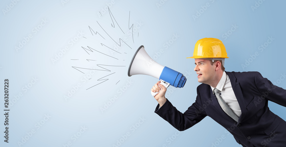 Fototapeta premium Young architect constructor yelling with megaphone and copyspace 