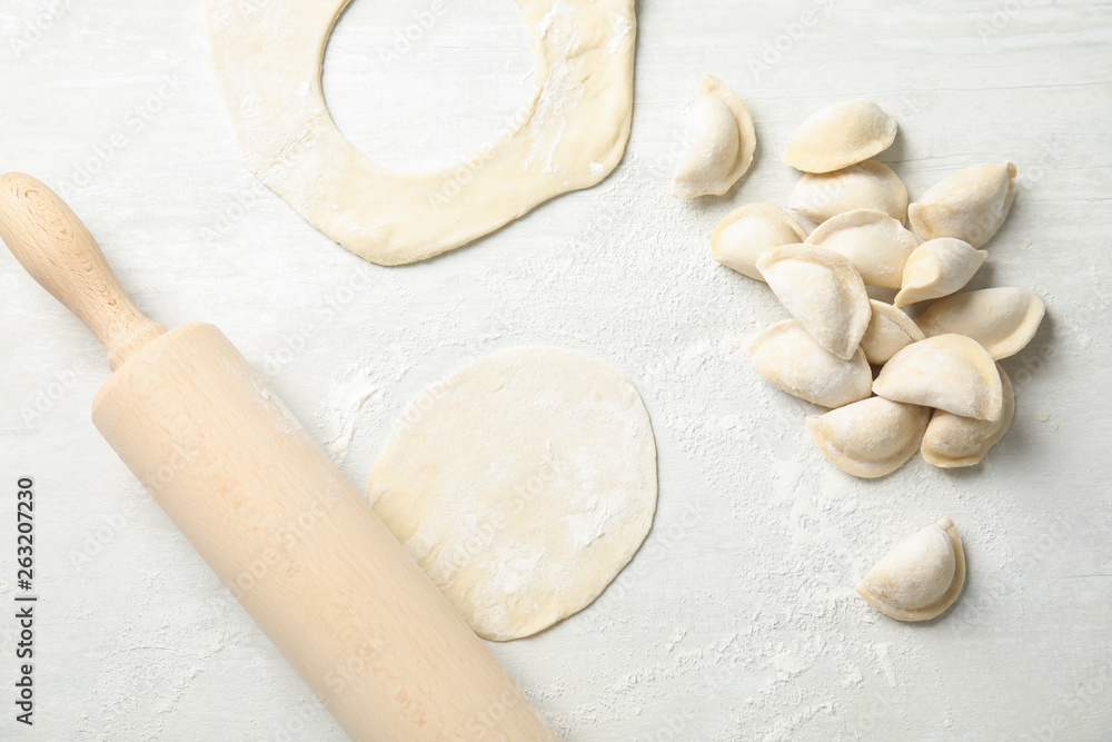 Flat lay composition with raw dumplings on light background. Process of cooking Flat lay composition with raw dumplings on light background. Process of cooking