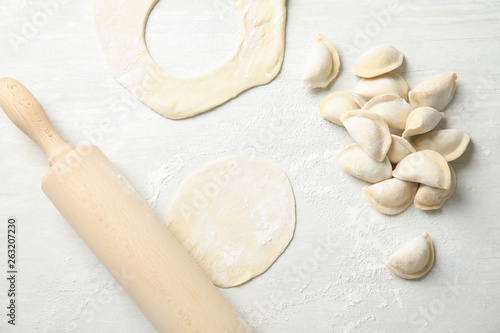 Flat lay composition with raw dumplings on light background. Process of cooking