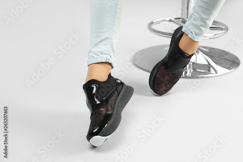 Woman in stylish shoes on grey background, closeup