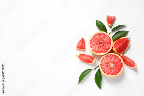 Grapefruits and leaves on white background, top view. Citrus fruits