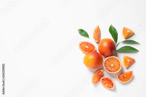 Fresh bloody oranges and leaves on white background, top view. Citrus fruits