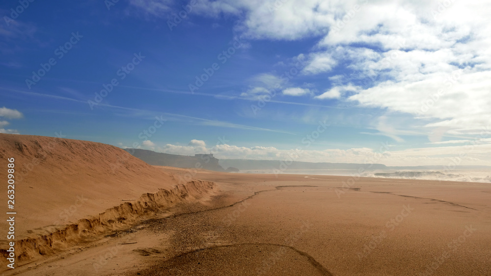 Wide deserted beach on the Atlantic coast in the town of Nazare Portugal