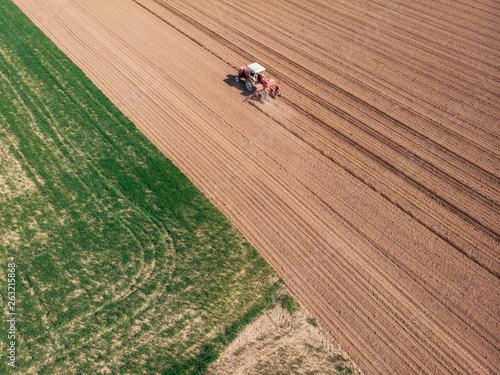 Fototapeta Naklejka Na Ścianę i Meble -  Aerial view of a tractor plowing the fields, aerial view, plowing, sowing, harvest. Agriculture and Farming, campaign. Desert and dehydrated lands, global warming
