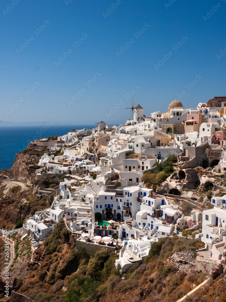 Oia village on the island of Santorini Greece is well known for its collection of white washed terraced apartments climbing up the side of the rock face.  