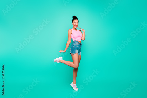 Full length side profile body size photo beautiful she her lady stylish hairstyle have walk park weekend wear casual pink tank-top jeans denim shorts outfit clothes isolated teal turquoise background © deagreez