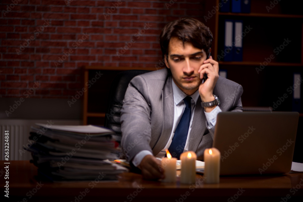 Businessman working late in office with candle light Businessman working late in office with candle light