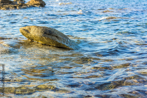 bright local scenery landscape with transparent blue water and stones above surface near waterfront