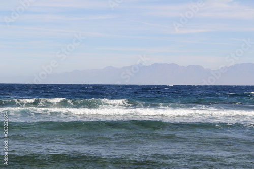 Sea with waves and mountains on the horizon