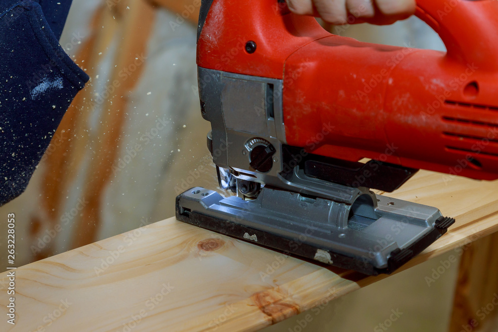 Close up electric jigsaw cutting a piece of wood Close up electric jigsaw cutting a piece of wood