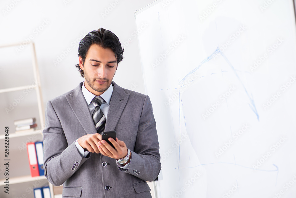 Young handsome businessman in front of whiteboard Young handsome businessman in front of whiteboard
