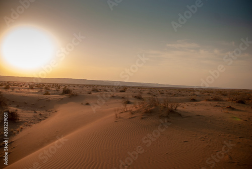 A view of a big burning sun in the wide desert