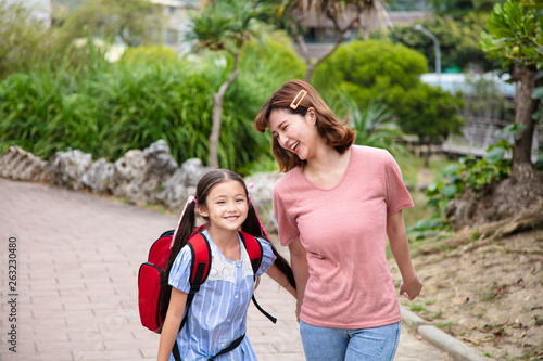 Mother and child holding hands going to school