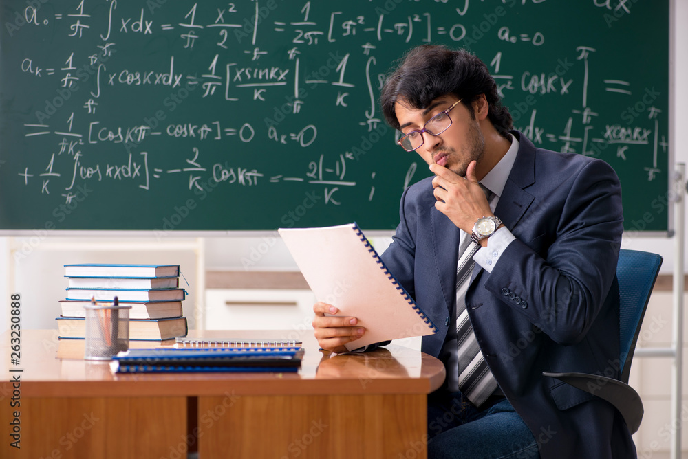 Young male math teacher in classroom 